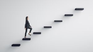 A woman in leadership attempting to walk up precariously spaced stairs